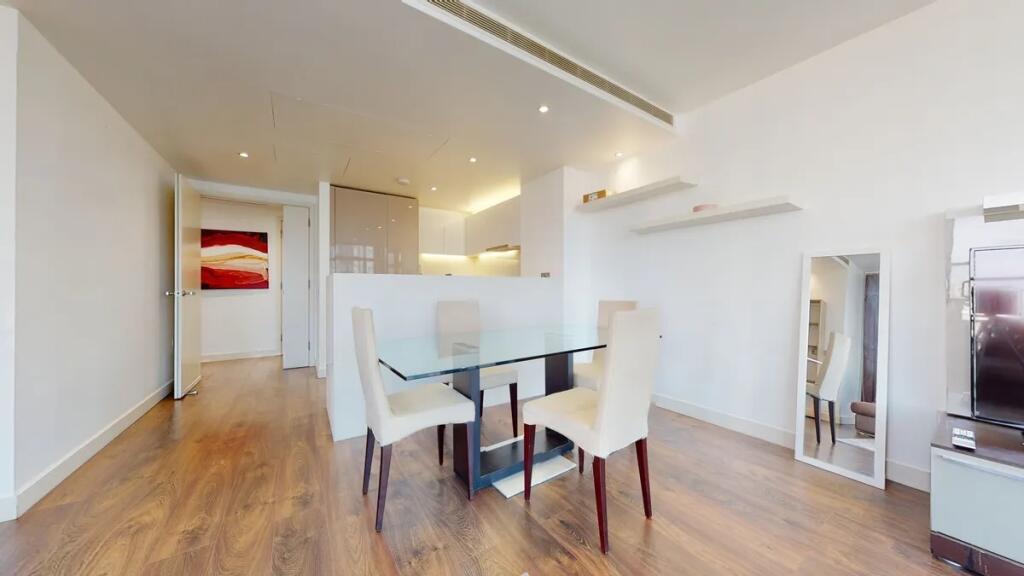 A modern living room featuring a sleek glass di...