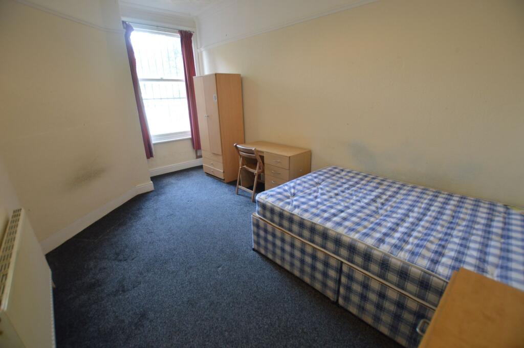 A compact single bedroom featuring a single bed...