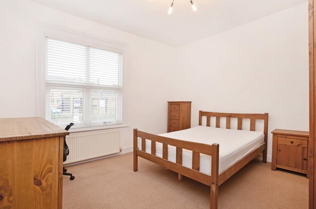 A bright and tidy spacious bedroom featuring a ...