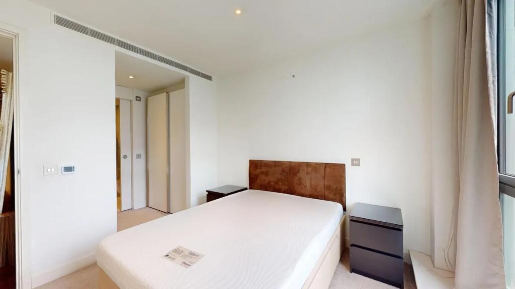 A bright double bedroom featuring a comfortable...
