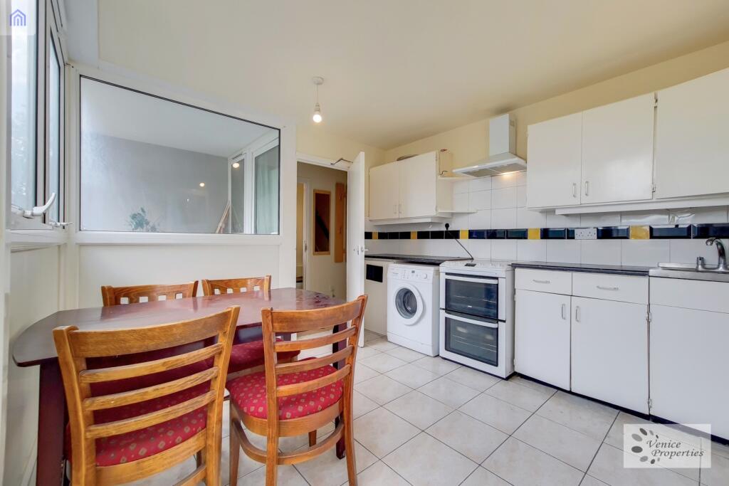 A bright and functional kitchen featuring white...