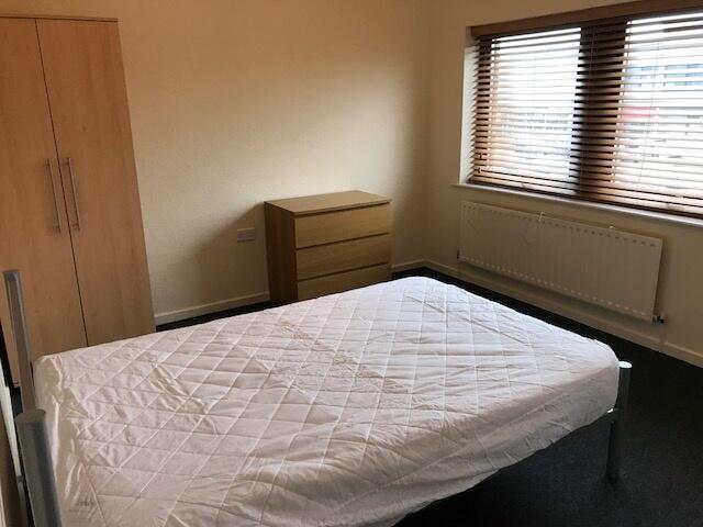 A tidy and well-lit bedroom featuring a single ...