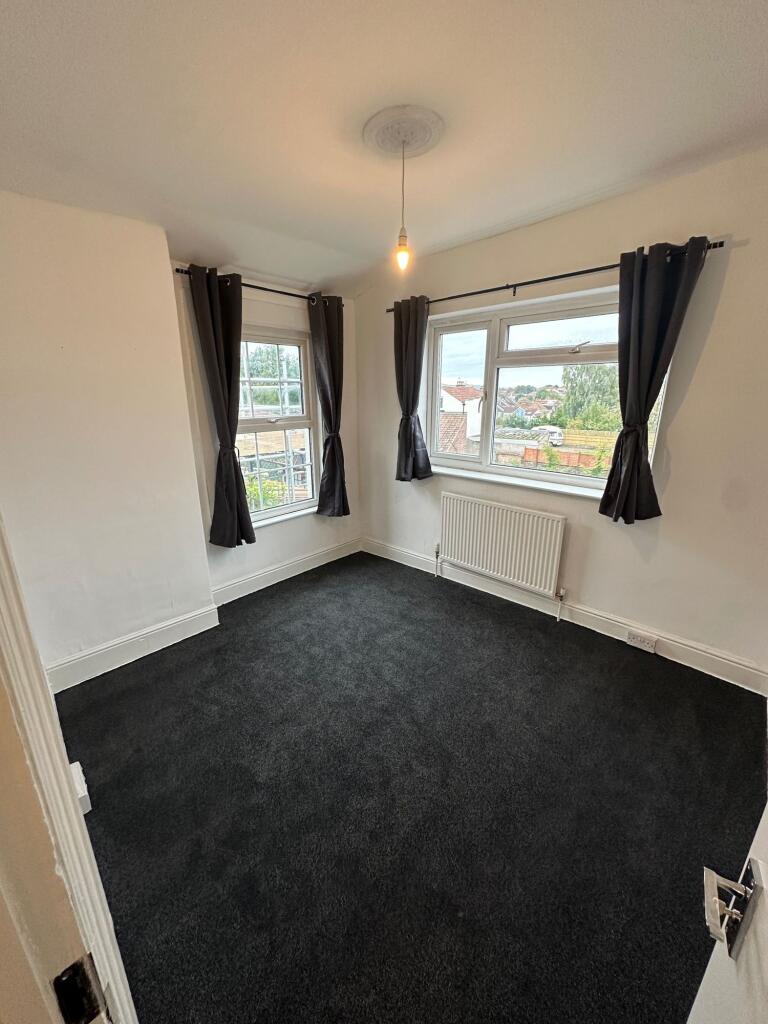 Bright double bedroom featuring two large windo...