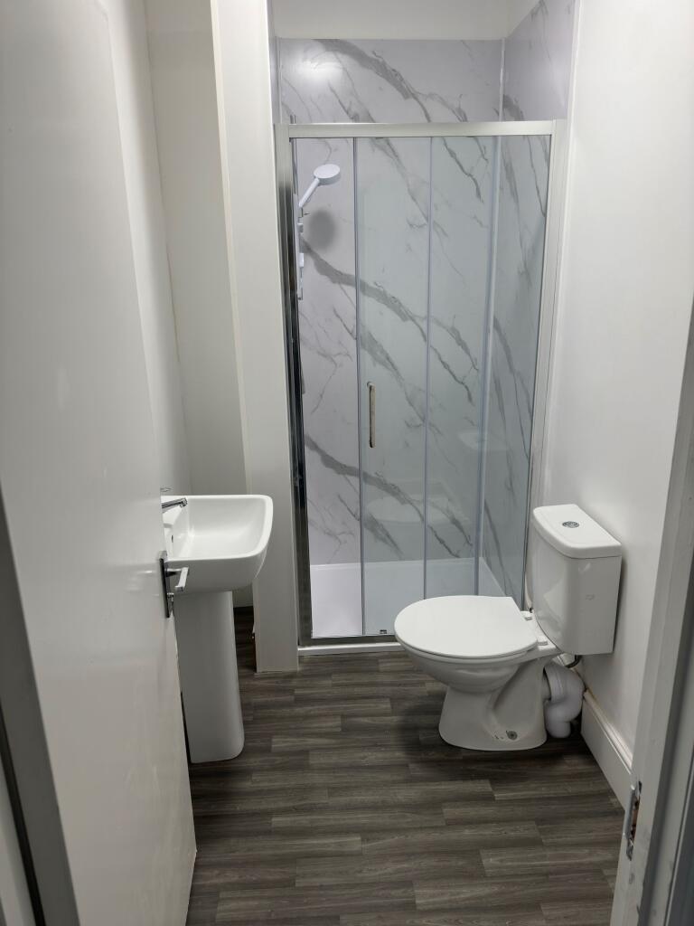 A modern and clean bathroom featuring a glass-e...