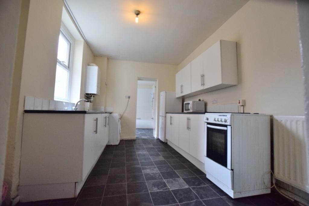 A spacious and tidy kitchen with ample storage ...