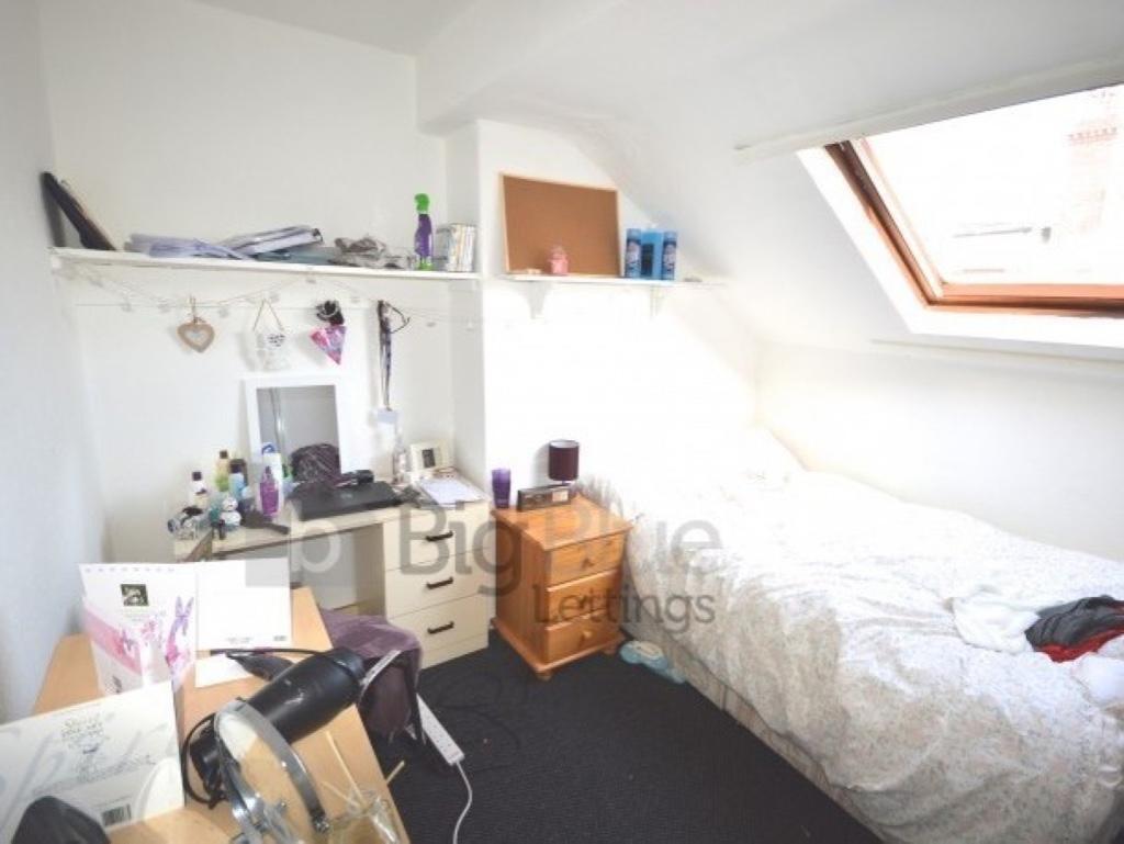 A bright single bedroom featuring a comfortable...