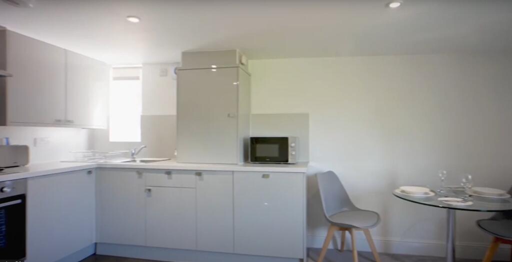 Well-equipped kitchen featuring modern applianc...