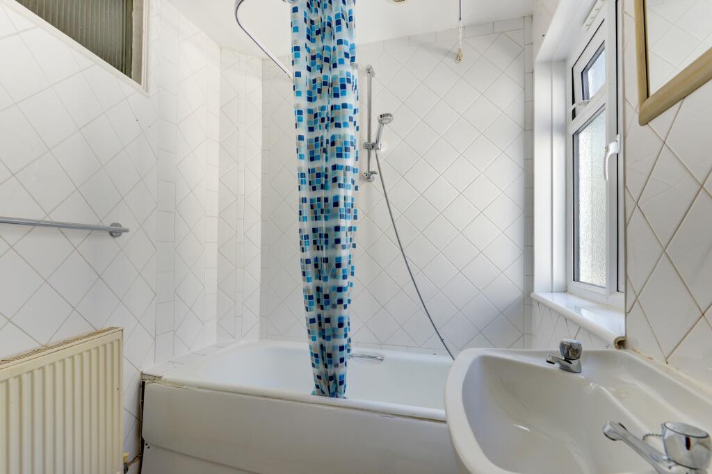 A clean and bright bathroom featuring a full ba...