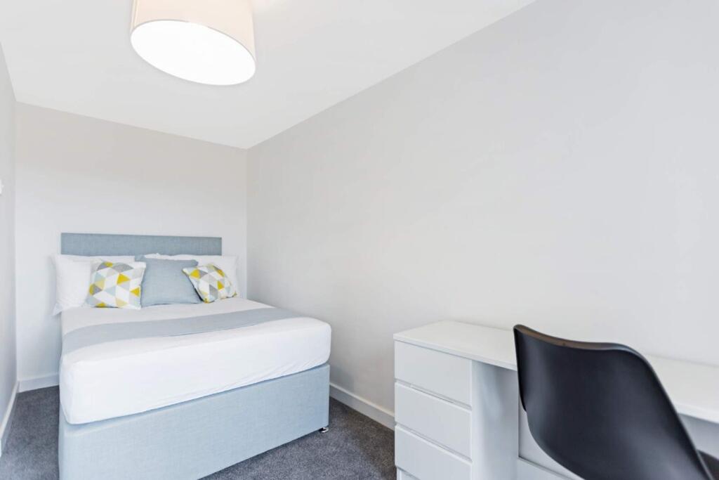 A bright and tidy double bedroom with modern de...