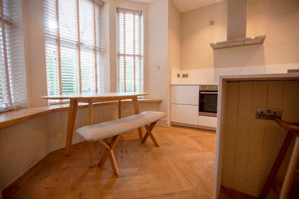 A bright and tidy kitchenette with ample natura...