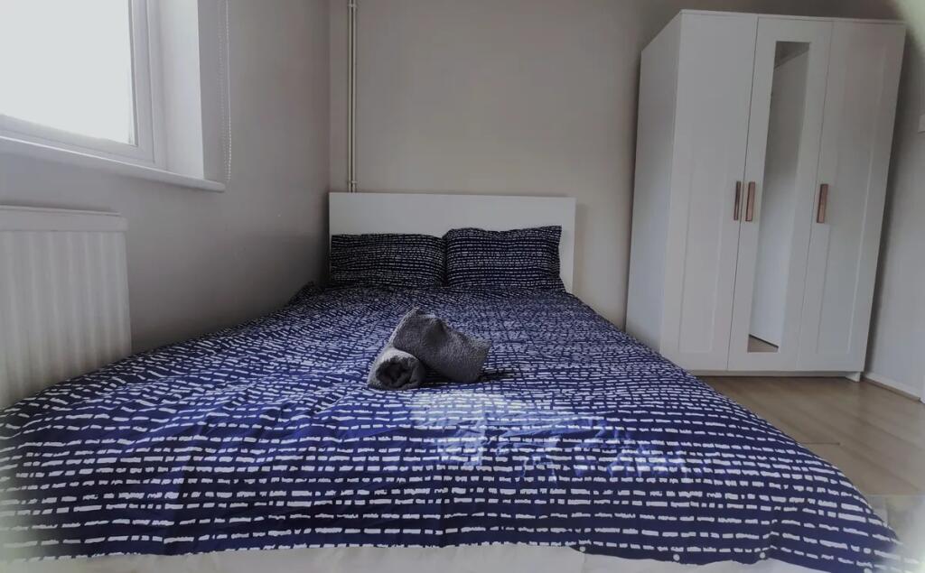 A cozy double bedroom featuring a neatly made b...