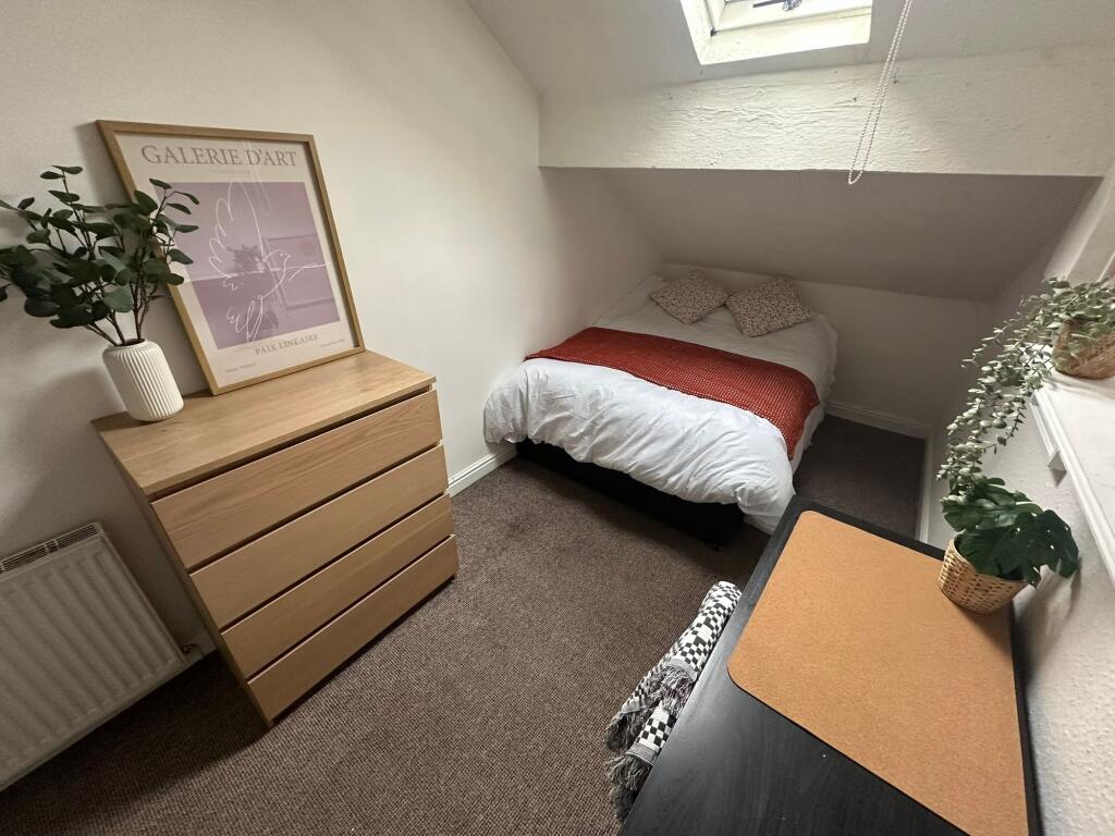 A cozy and well-maintained double bedroom with ...