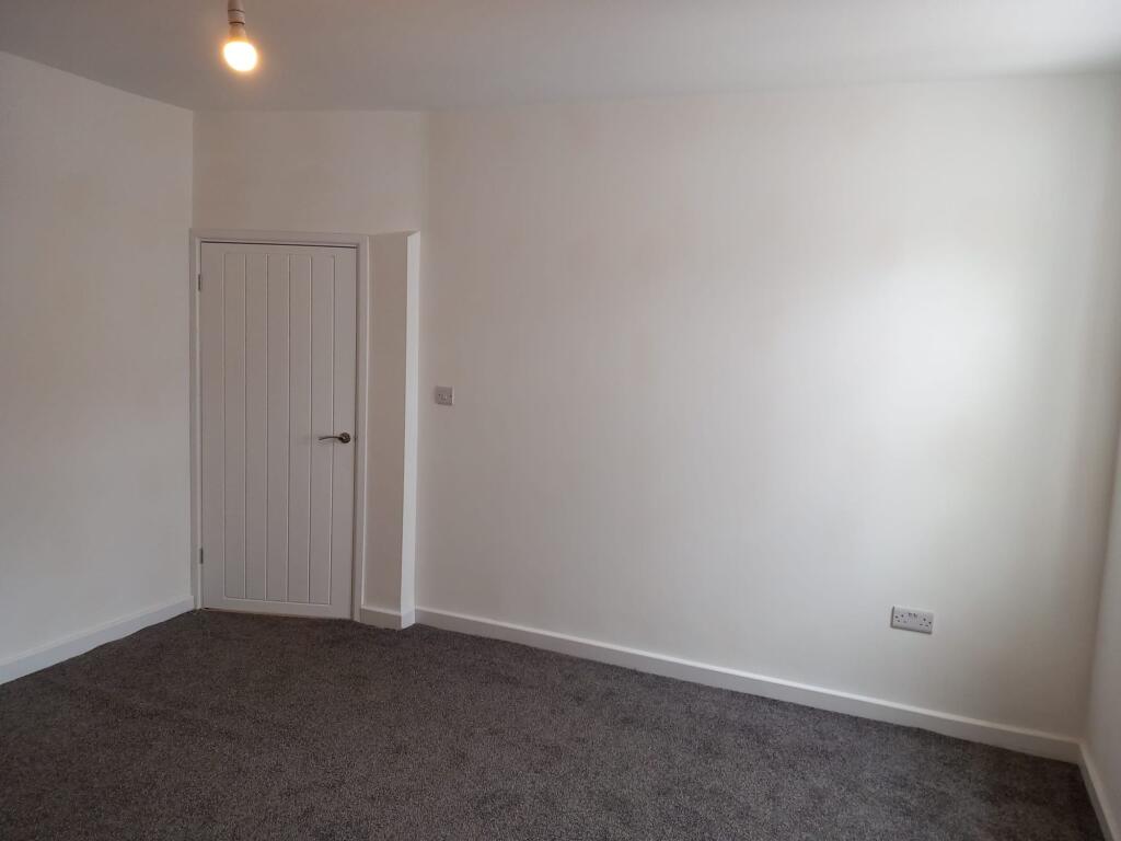 A clean and freshly painted single bedroom with...