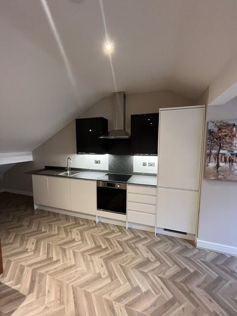 A modern, well-maintained kitchen with sleek bl...