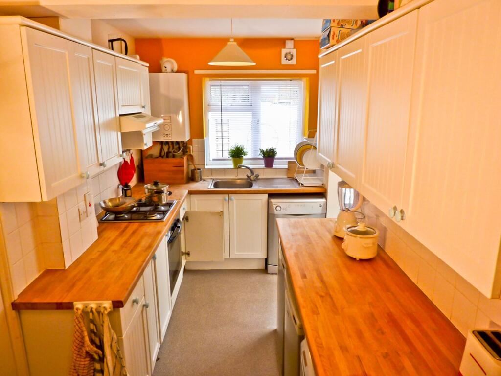 A bright and modern kitchen featuring ample cou...