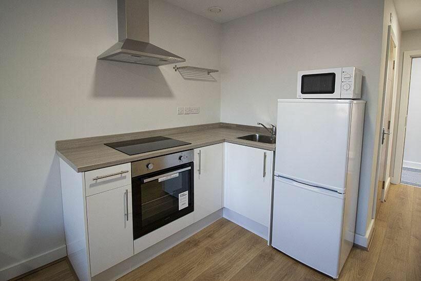 Bright and modern kitchen featuring white cabin...