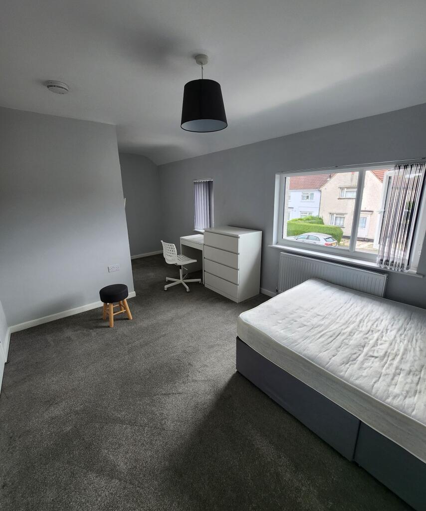 Bright and spacious bedroom with large window a...