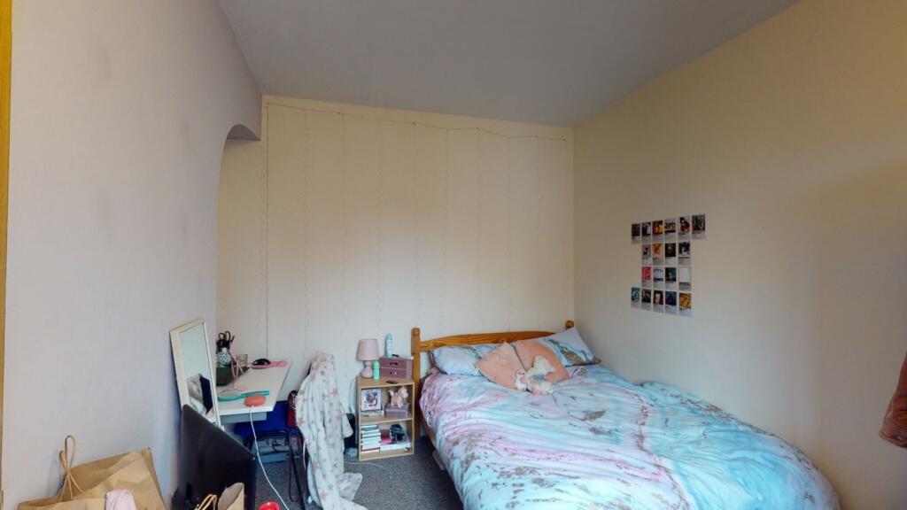 A cozy single bedroom with a comfortable bed, d...