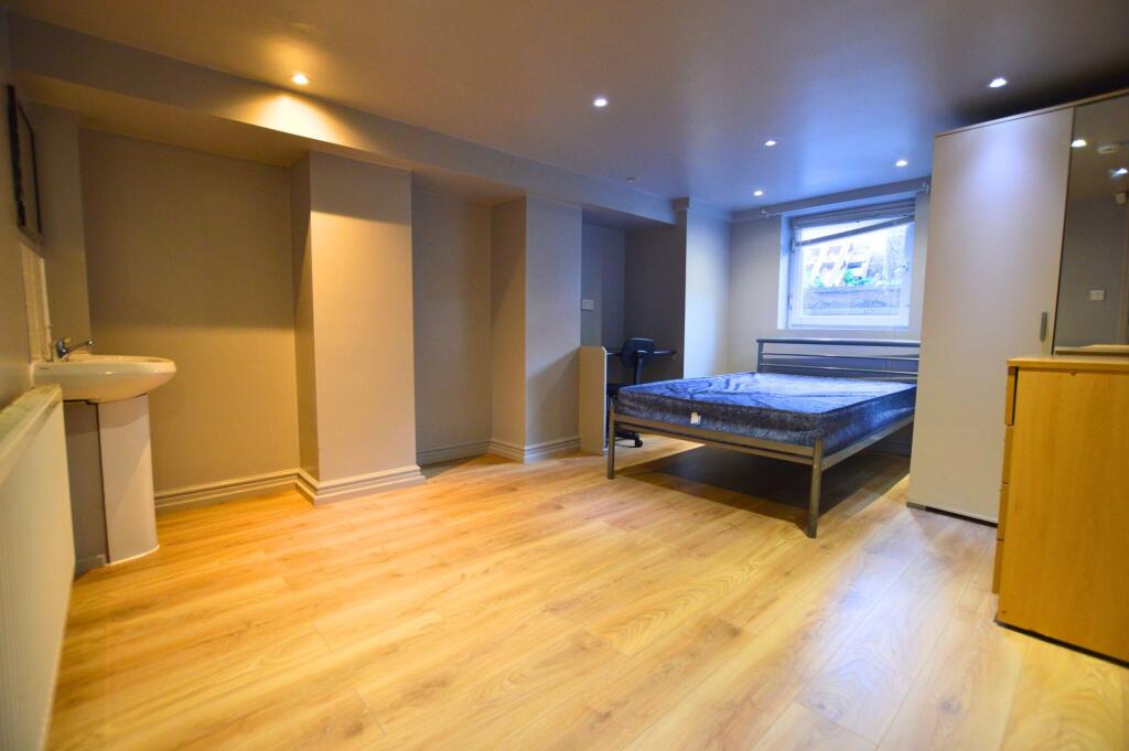 Spacious double bedroom with warm wood flooring...