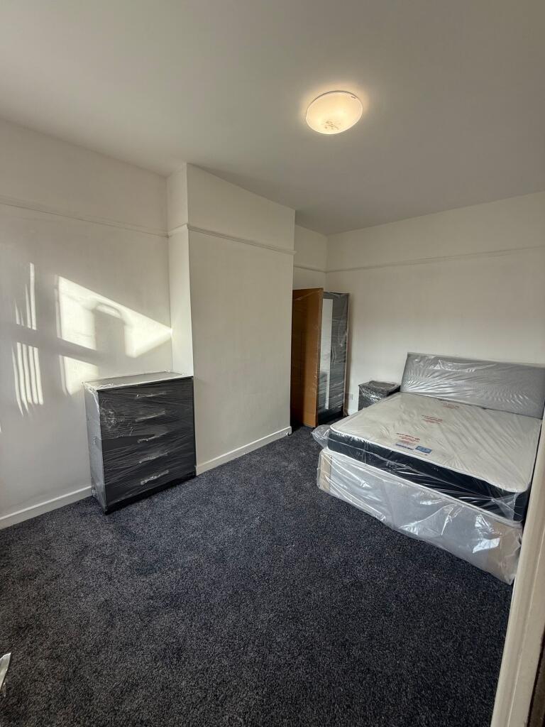 A tidy, simply furnished bedroom highlighted by...
