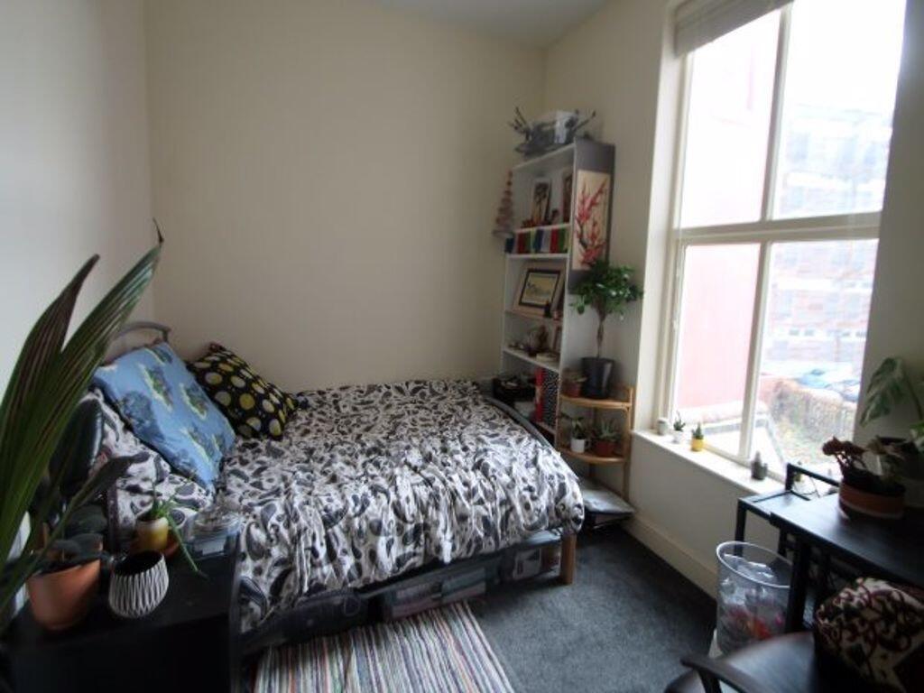 A cozy single bedroom featuring a comfortable b...