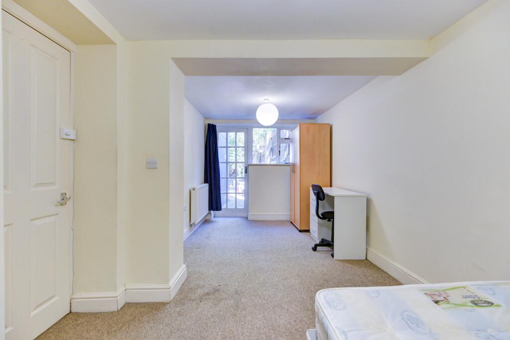 A bright and clean single bedroom featuring a w...