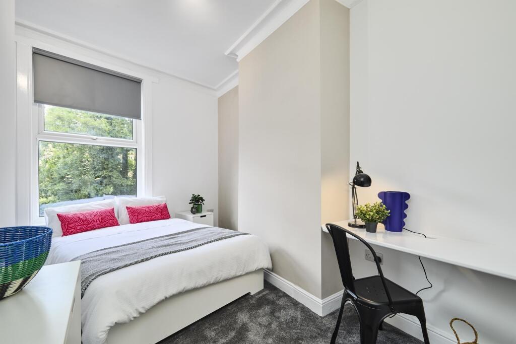 Bright and welcoming bedroom with a comfortable...