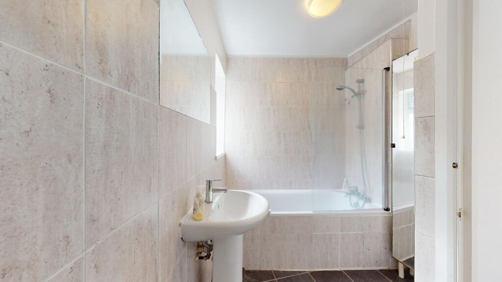 Bright and clean bathroom suite featuring a bat...
