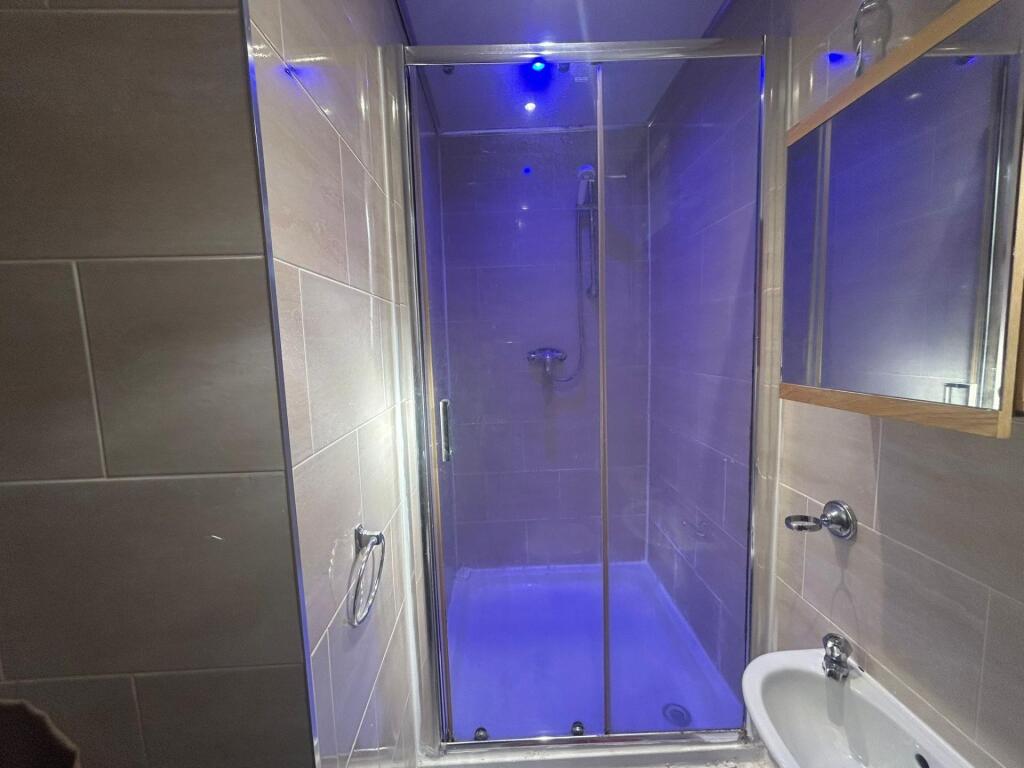 Modern and clean bathroom with a shower enclosu...