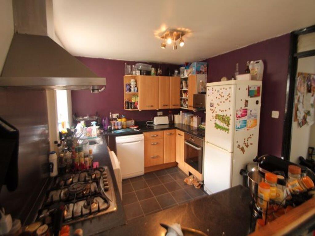 A cozy kitchen with warm purple walls, wooden c...