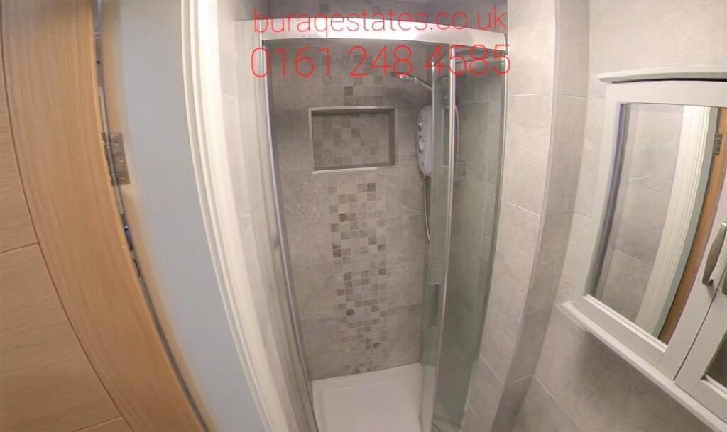 Modern shower cubicle with patterned tile accen...
