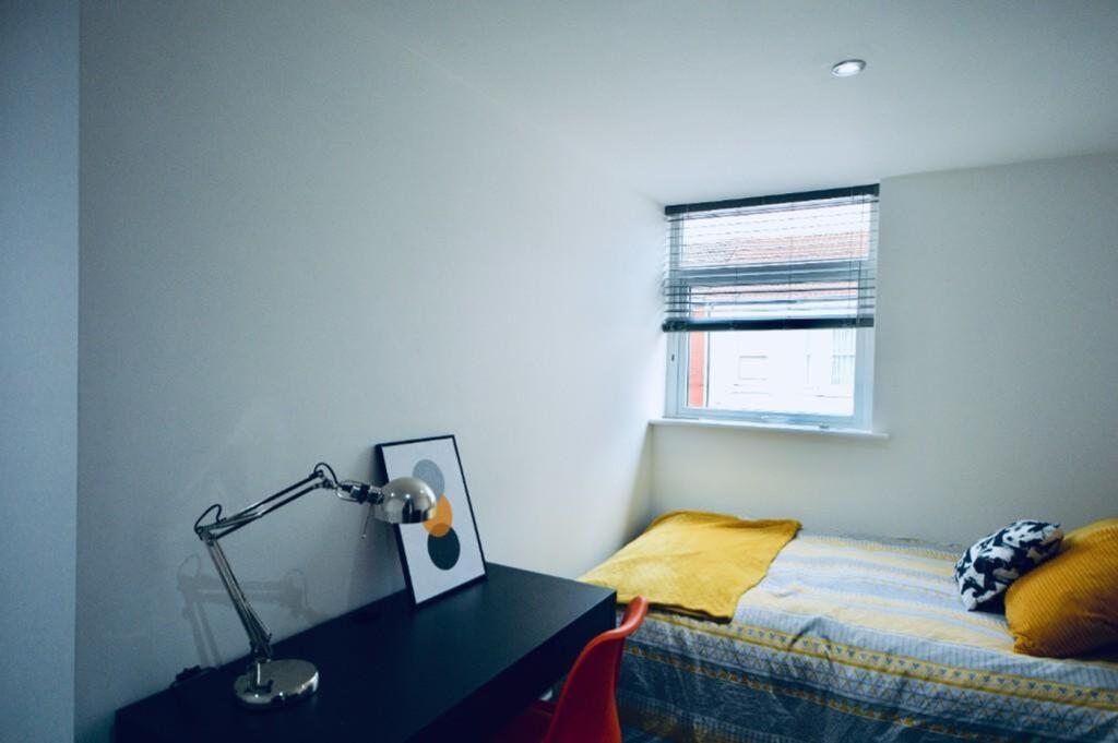 A bright and tidy single bedroom featuring a co...