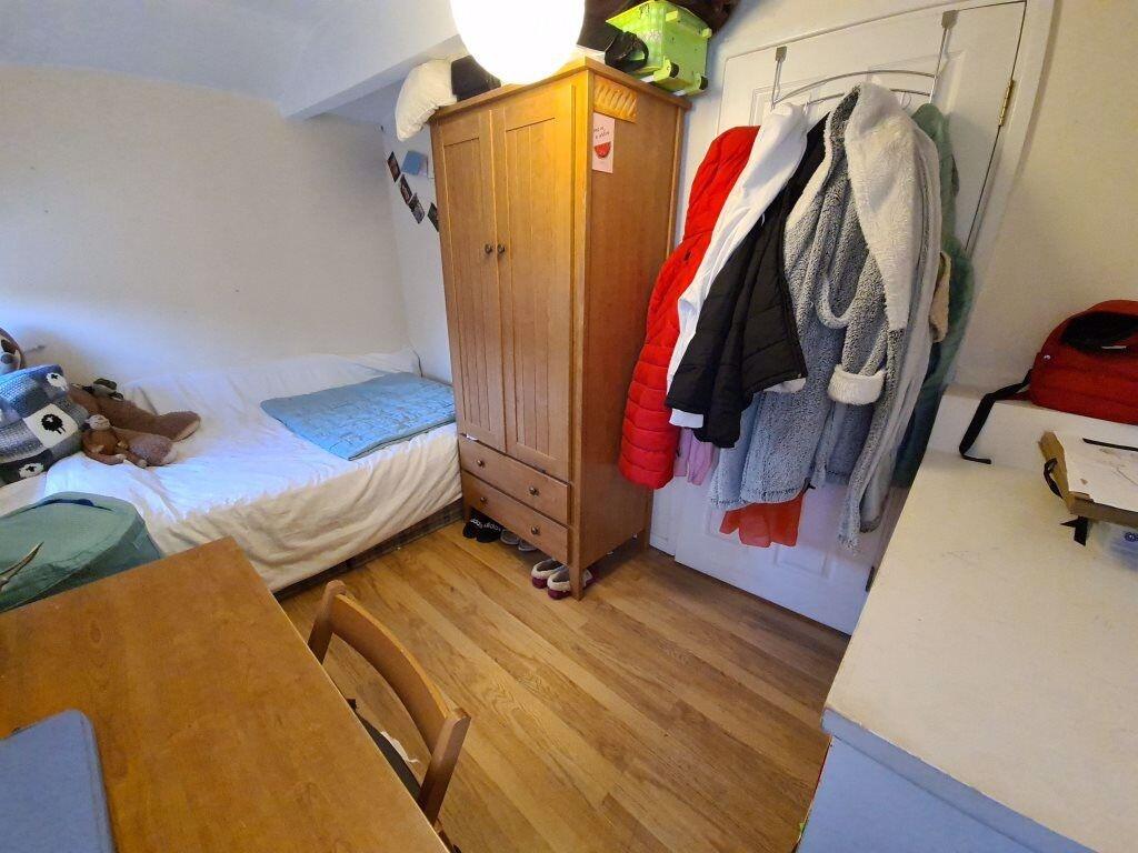 A cozy single bedroom featuring a neatly made s...