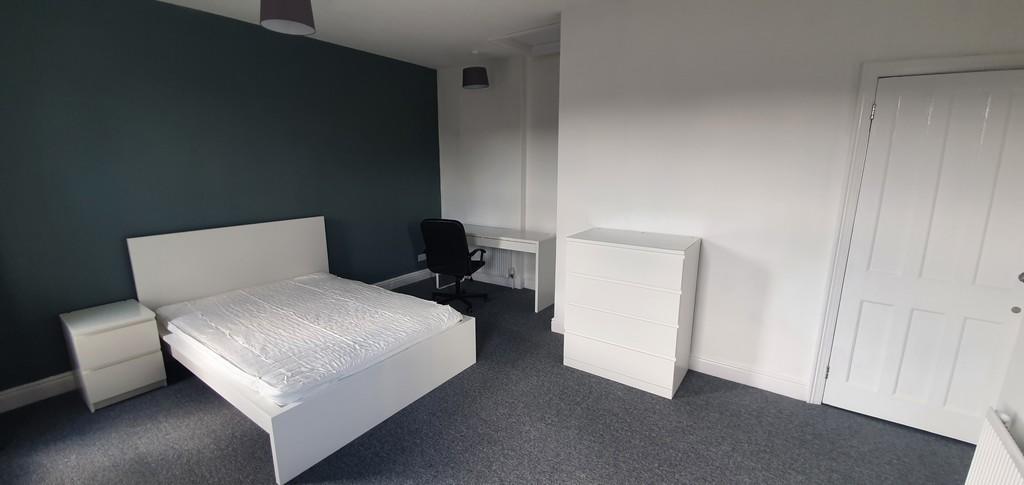 Spacious and tidy master bedroom featuring a co...