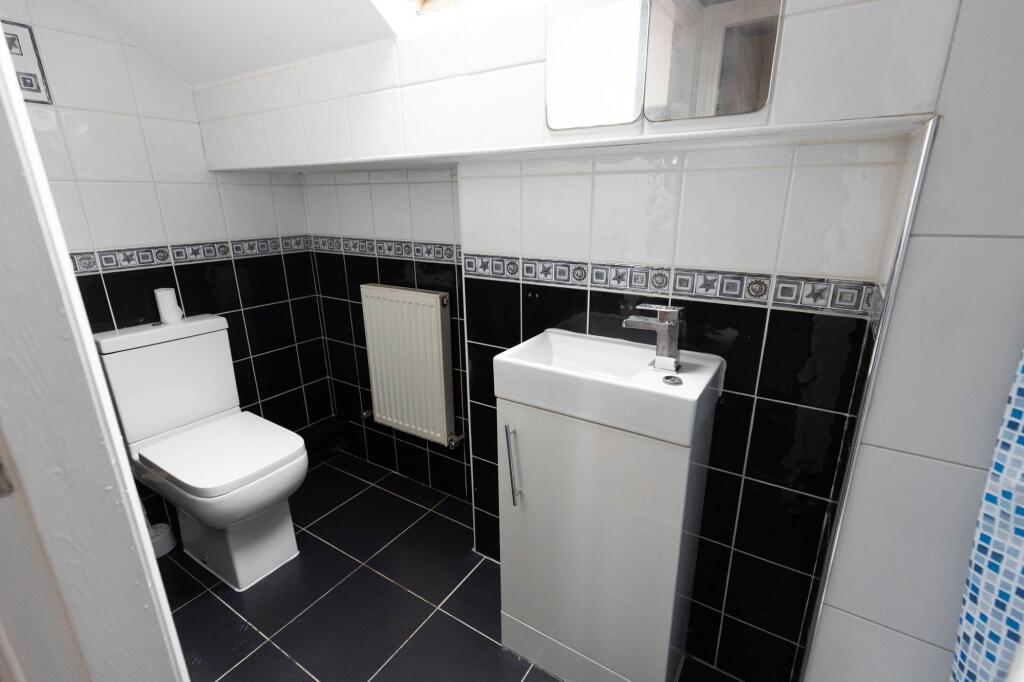 Modern bathroom with a toilet and a small sink,...