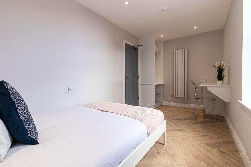 A bright and modern bedroom featuring a comfort...