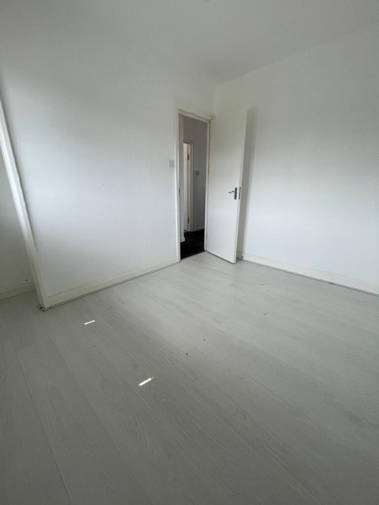 A clean, empty room with white walls and light ...