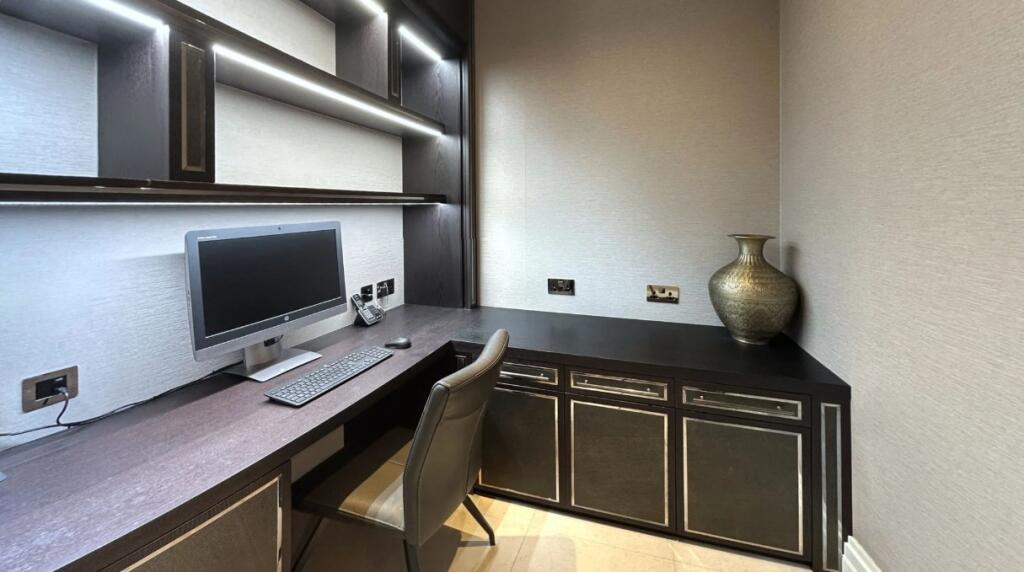 A modern communal workspace featuring a sleek b...