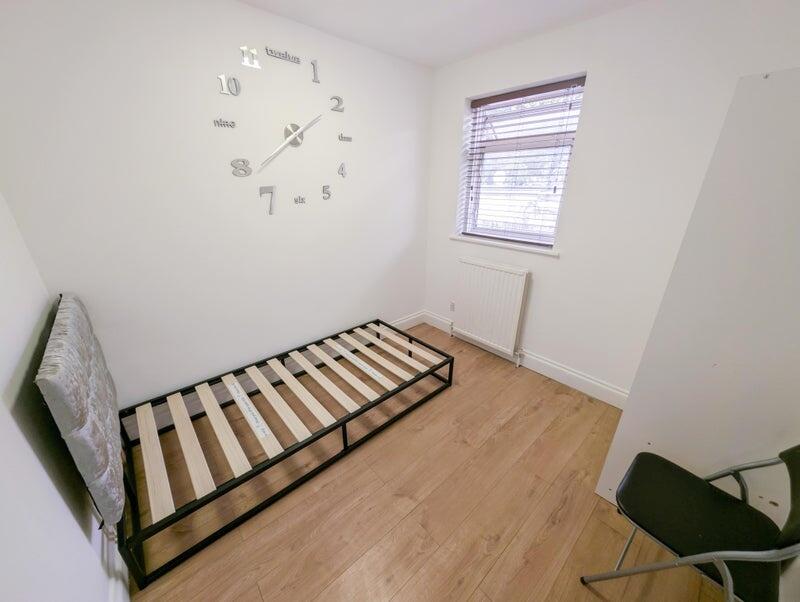 A neat and clean single bedroom with light wood...