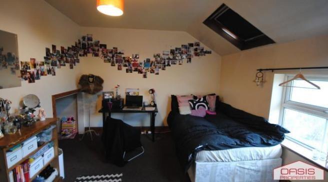 A cozy bedroom featuring a large bed and a wind...