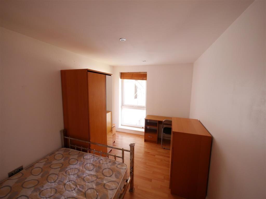 A simple and tidy single bedroom featuring wood...