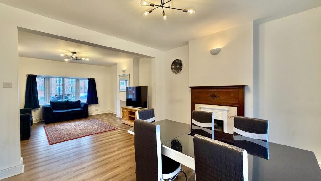 Bright, open-plan living area with wood-effect ...