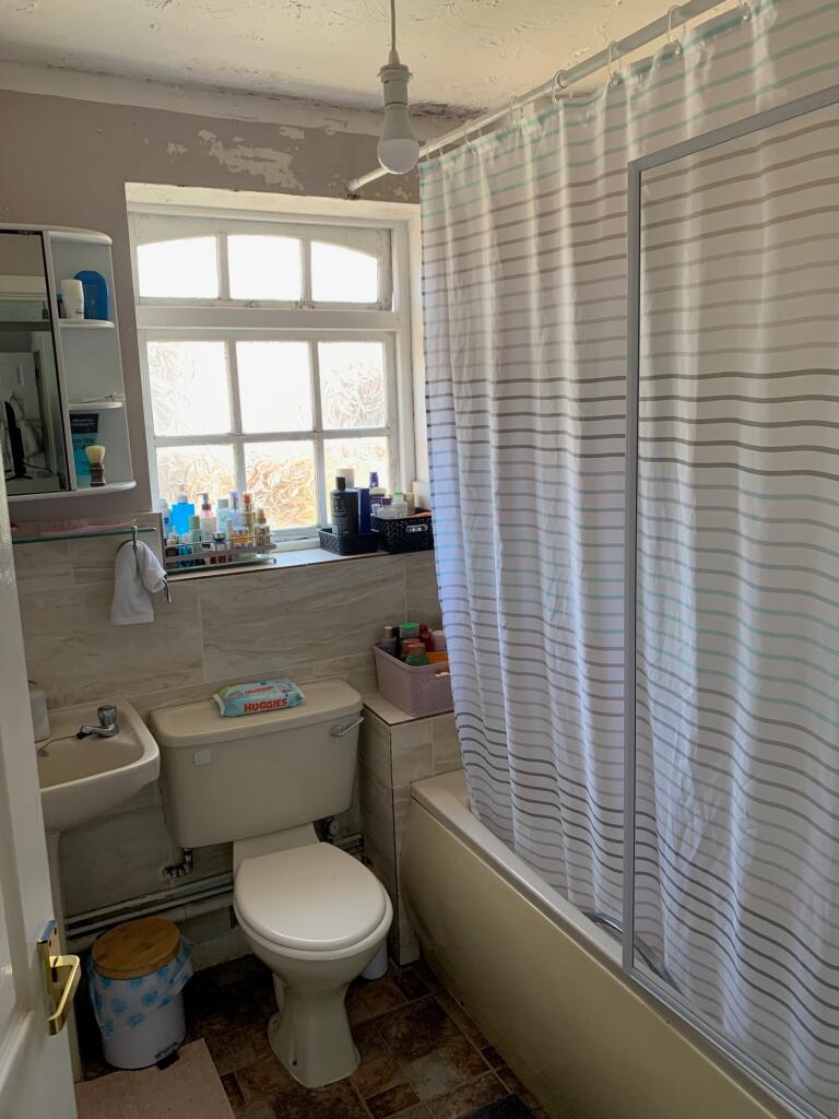 A bright and tidy bathroom featuring a shower a...