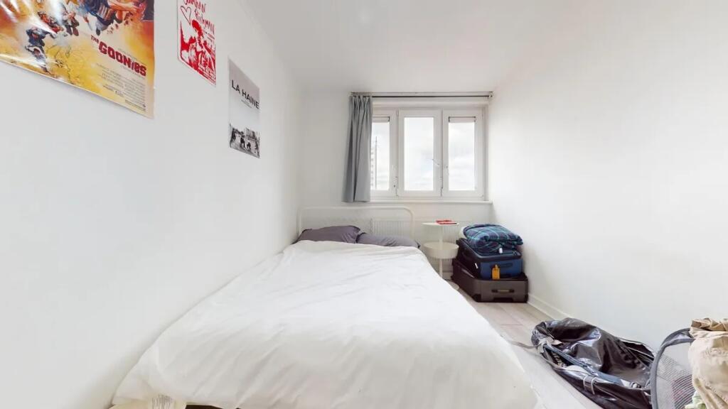 A bright, tidy single bedroom with a white bed ...
