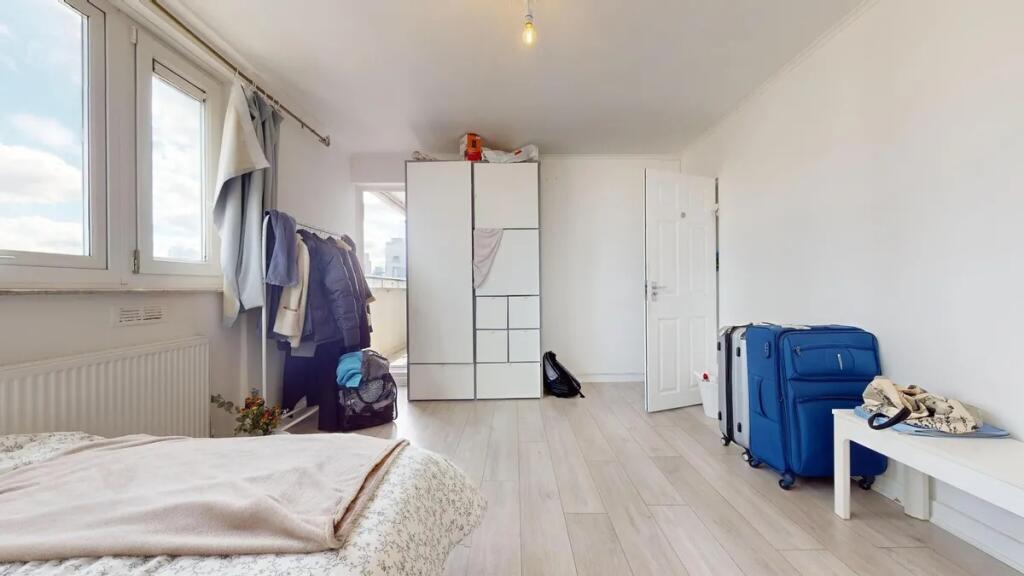 A bright, clean single bedroom featuring light ...