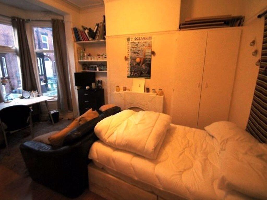 Cozy single bedroom featuring a comfortable bed...