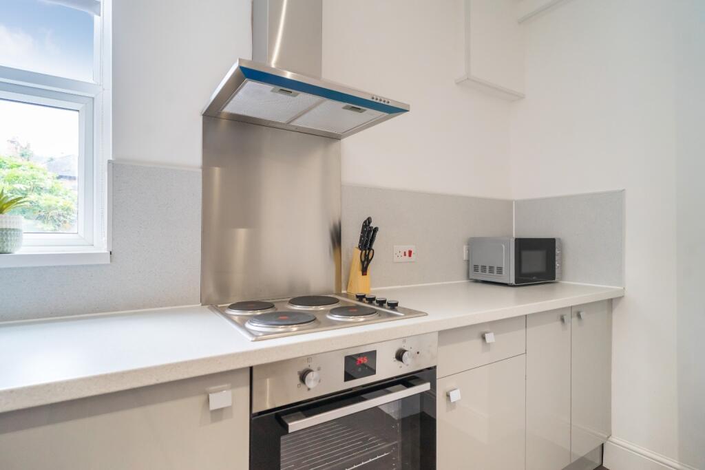 Bright and modern kitchen featuring sleek cabin...