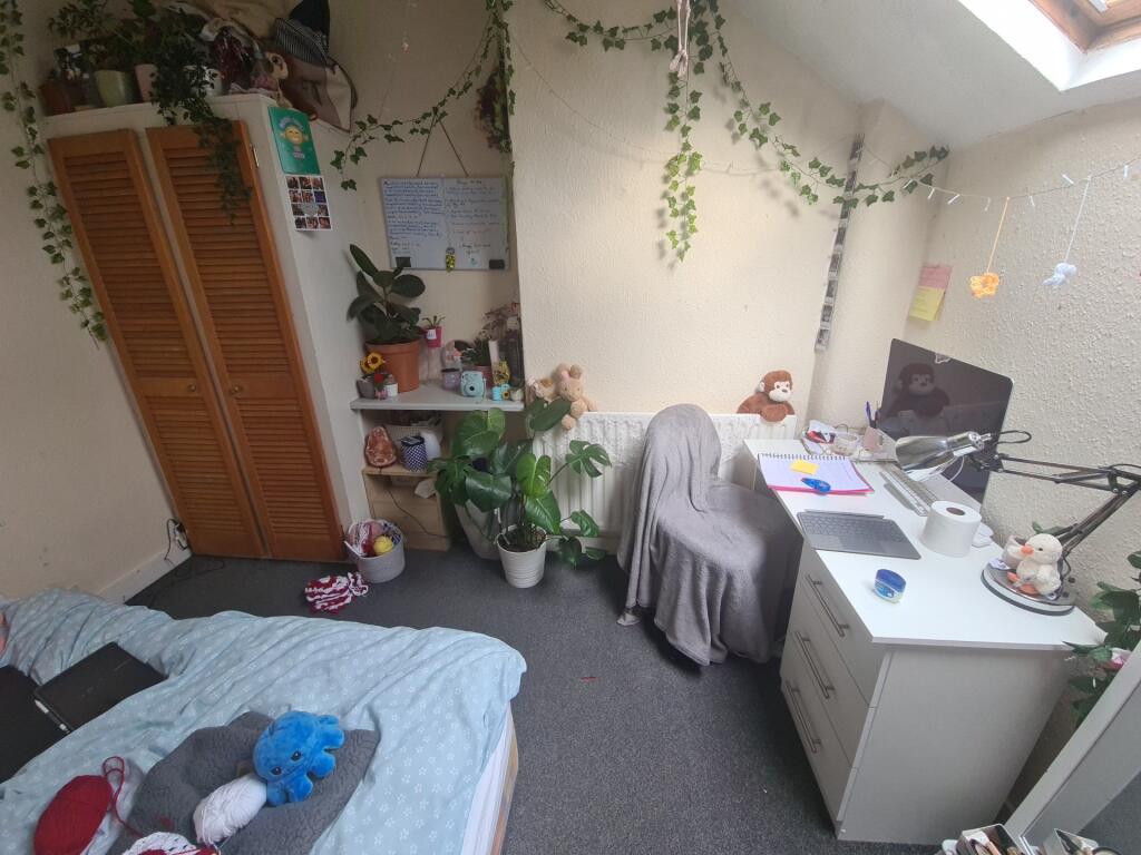 Cozy single bedroom featuring a skylight window...