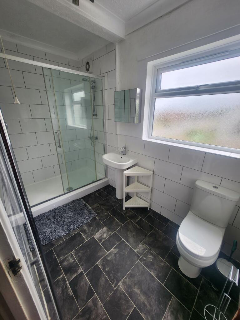Bright and clean bathroom featuring a large sho...