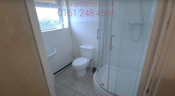 Bright and clean bathroom featuring a curved gl...
